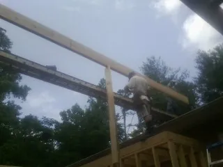 Carpenter setting a ridge beam over a new addition frame — Ice Dam Removal by Roofing Brothers in Tannersville