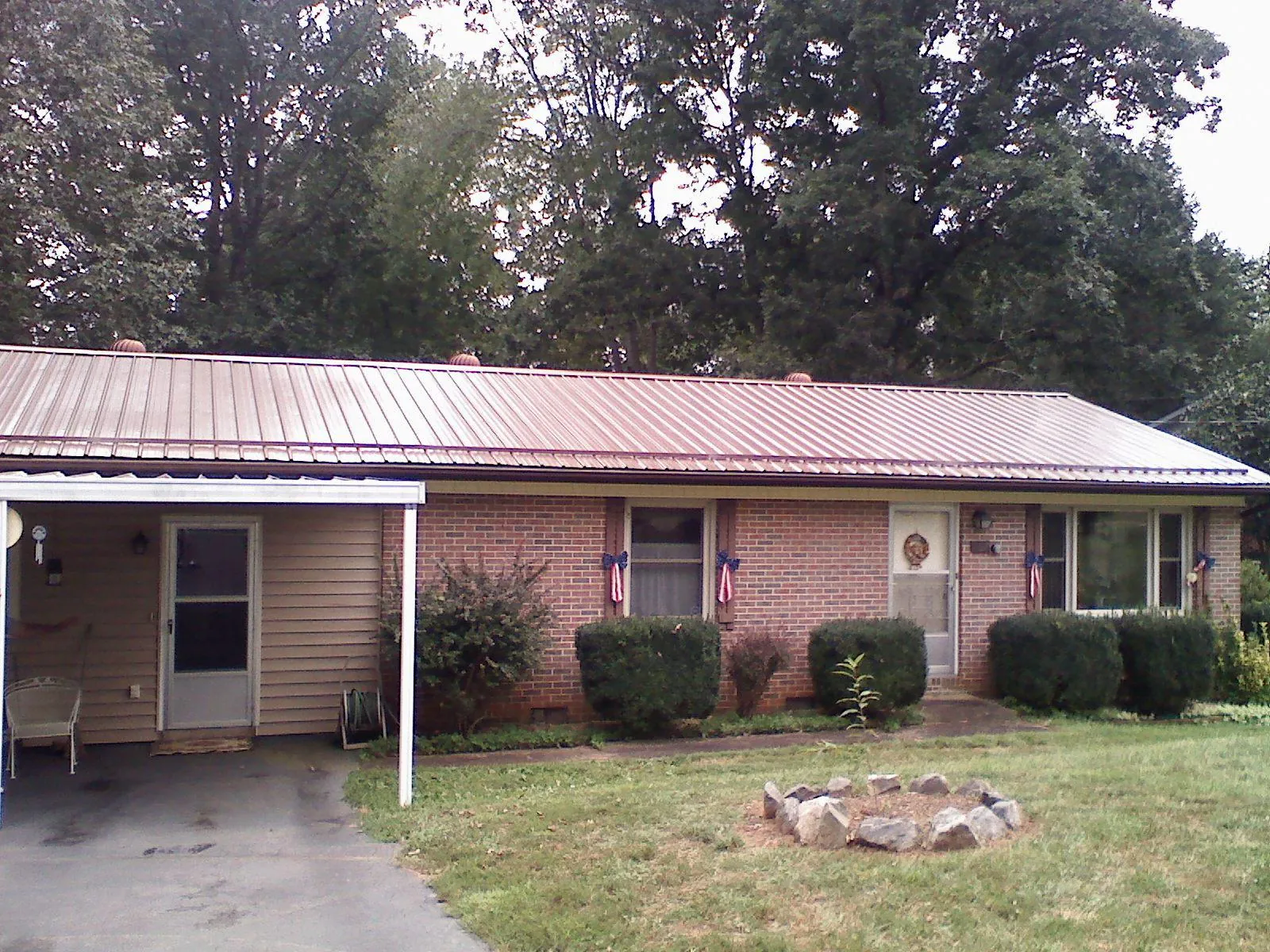 Bronze metal roof and carport on a brick ranch home — Roof Repair work by our crew in Tannersville
